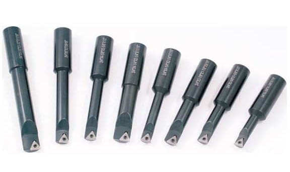 Seven black boring bars with silver tips on a white background.